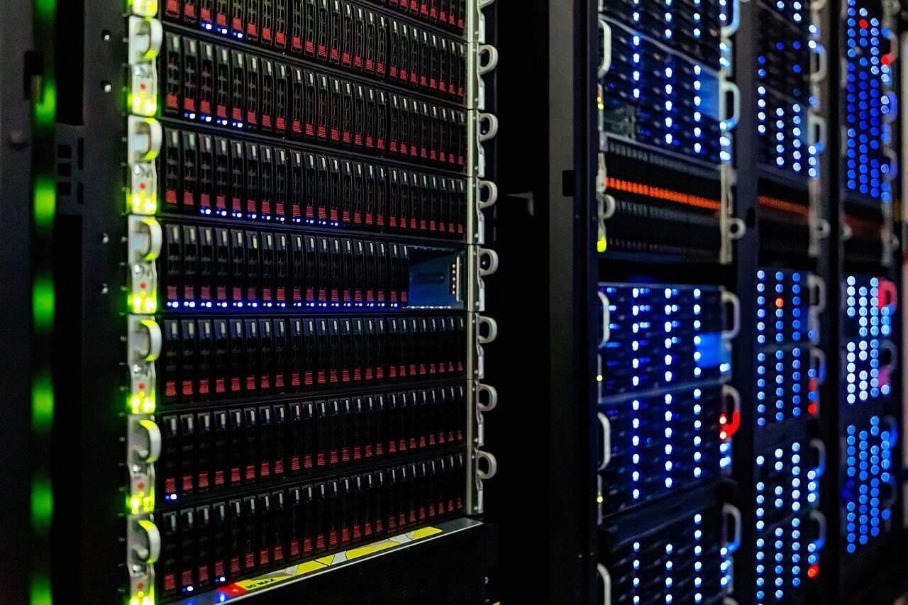 Rows of storage bays and status lights inside a data centre, where streamed titles run remotely